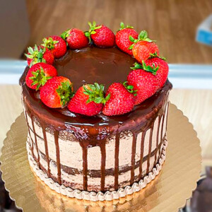 Chocolate cake with chocolate frosted, strawberries and ganache