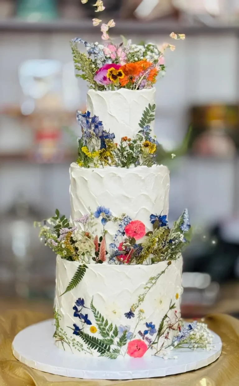 Four-tier wedding cake with pressed wildflowers