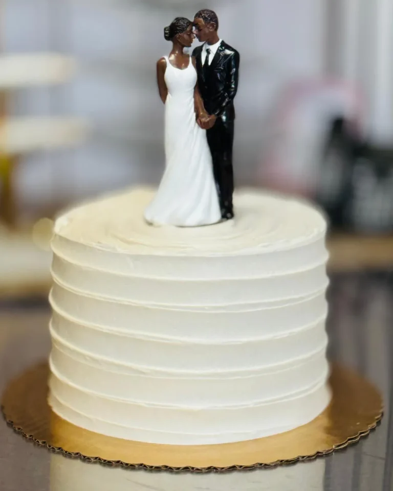 Ribbed buttercream wedding cake with a bride and groom topper