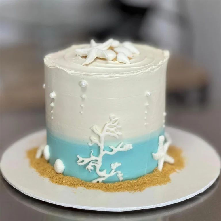 White and aqua beach cake with white coral, starfish and sand