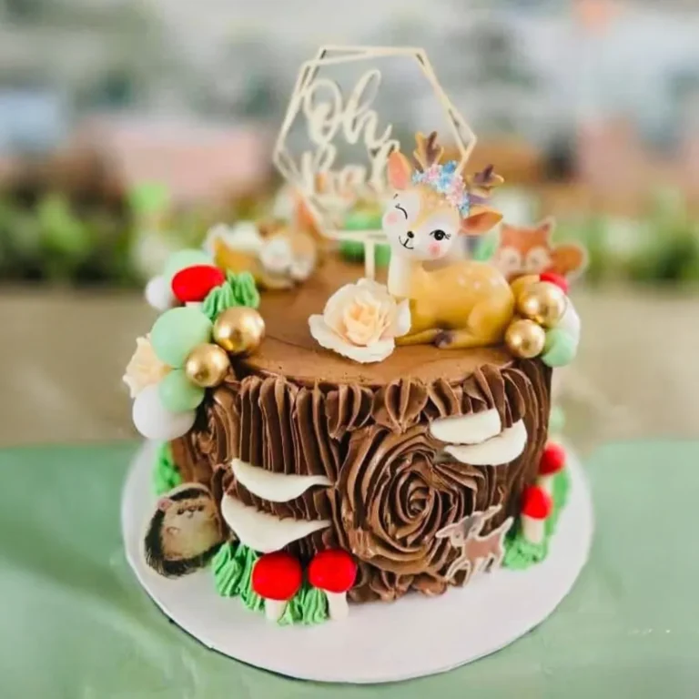 Woodland tree-stump cake with a baby deer, mushrooms and an "Oh baby" topper